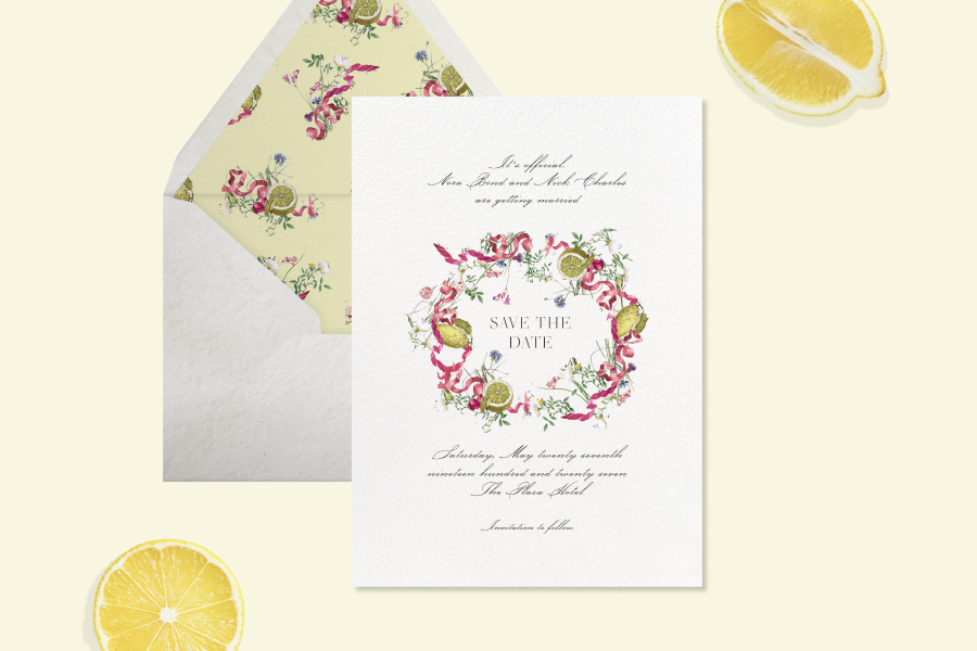 Save the date card with a white background featuring a pink ribbon and lemon crest design in the center, with a white envelope with a yellow liner.
